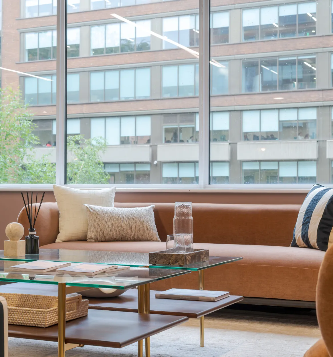 Curved sofa and glass coffee table in front of floor-to-ceiling glazing