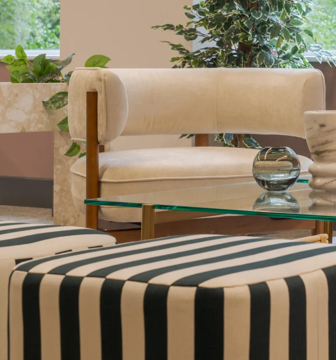 Striped ottoman, armchair and planting in the lounge